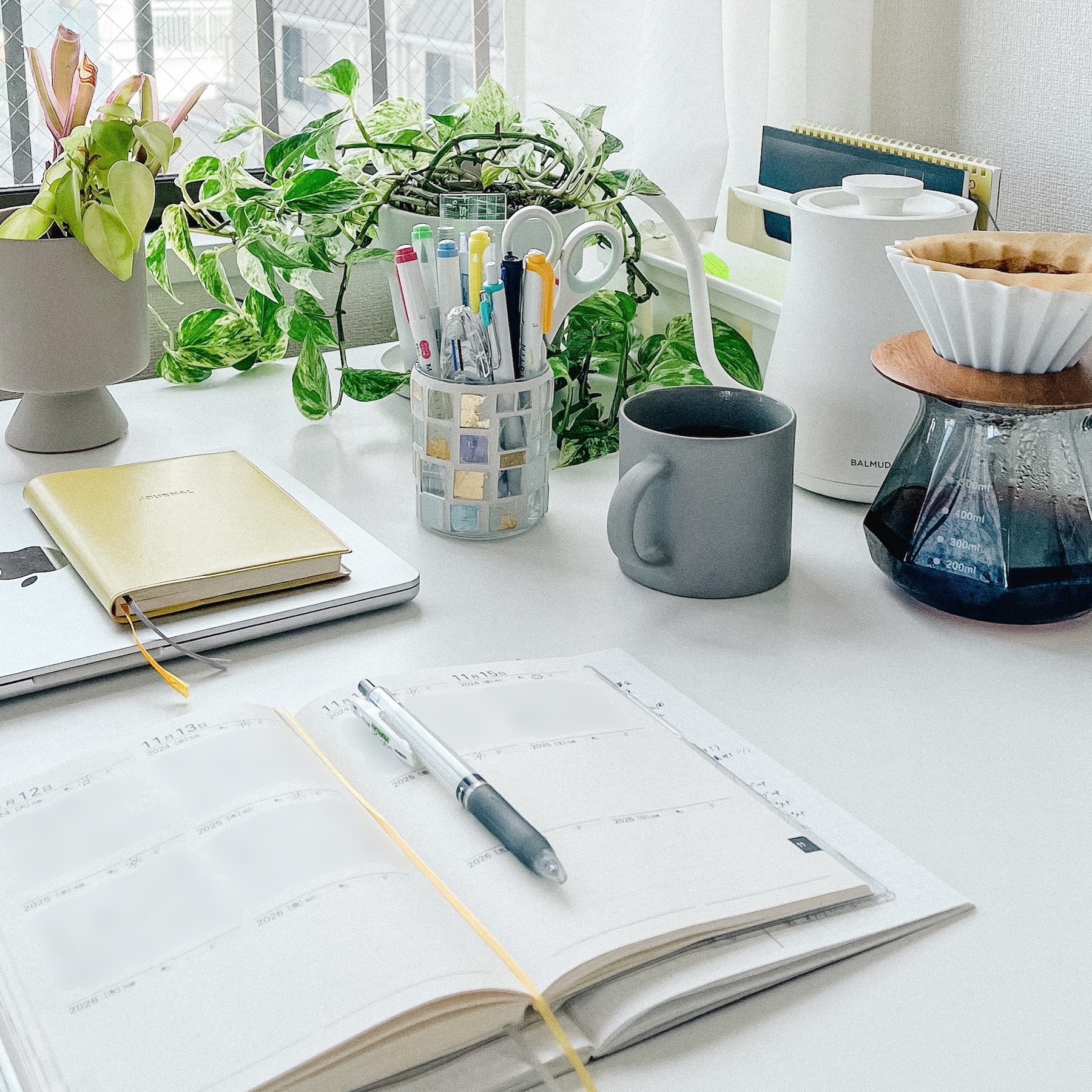 コーヒーとペンと日記帳が置かれたテーブル。日記を書く日常の風景